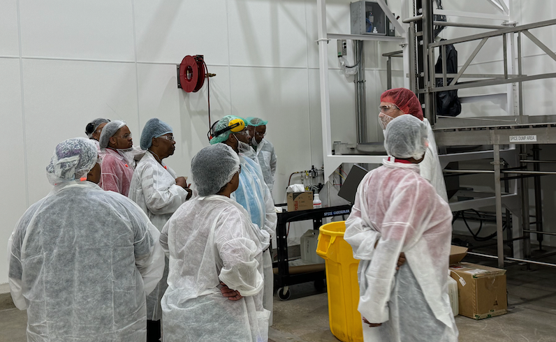 Manufacturing employees gathered around an interviewer